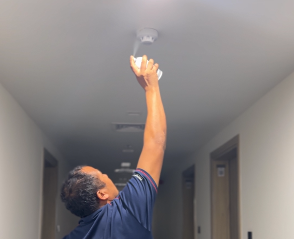 Close-up of a sprinkler head being checked during routine PPM in a Dubai community.